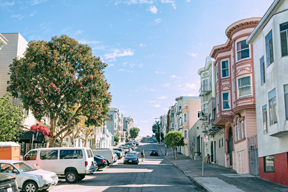 row of houses and a row of cars parked on the street